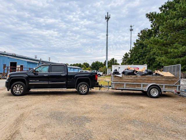 Lima Haul Co. truck and trailer loaded with bagged debris at a property cleanout