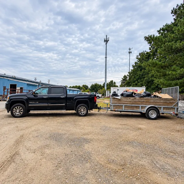 Lima Haul Co. truck and utility trailer loaded with bagged debris and materials at a jobsite